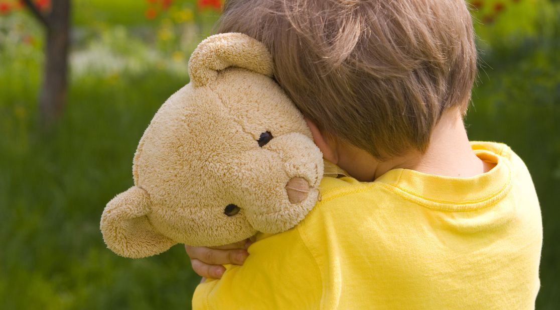 Schmuckbild: Kleiner Junge mit Teddybär im Arm