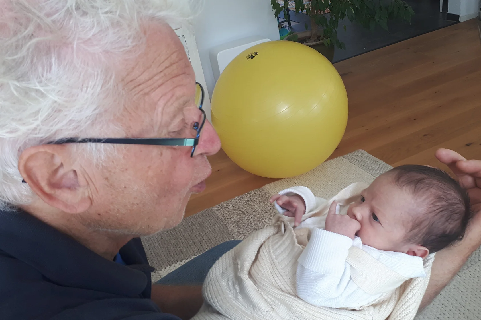 Großvater hält Enkelkind im Arm.