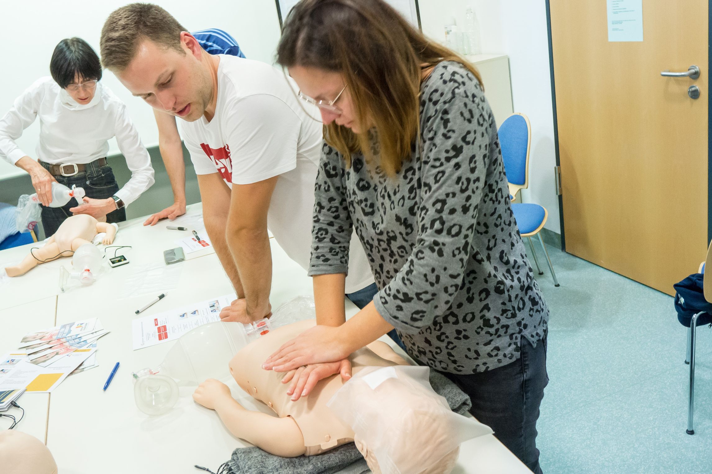 Der Trainer zeigt einer Mutter, wie Reanimation funktioniert
