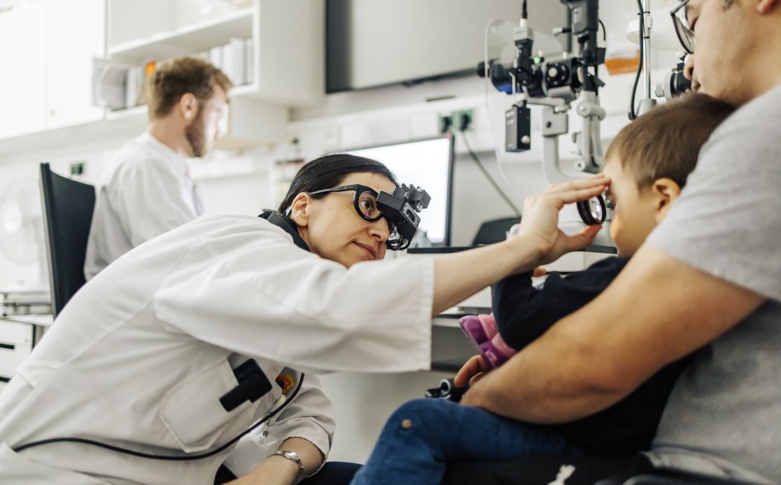 Titelseite Magazin: Ärztin untersucht Auge eines Kindes