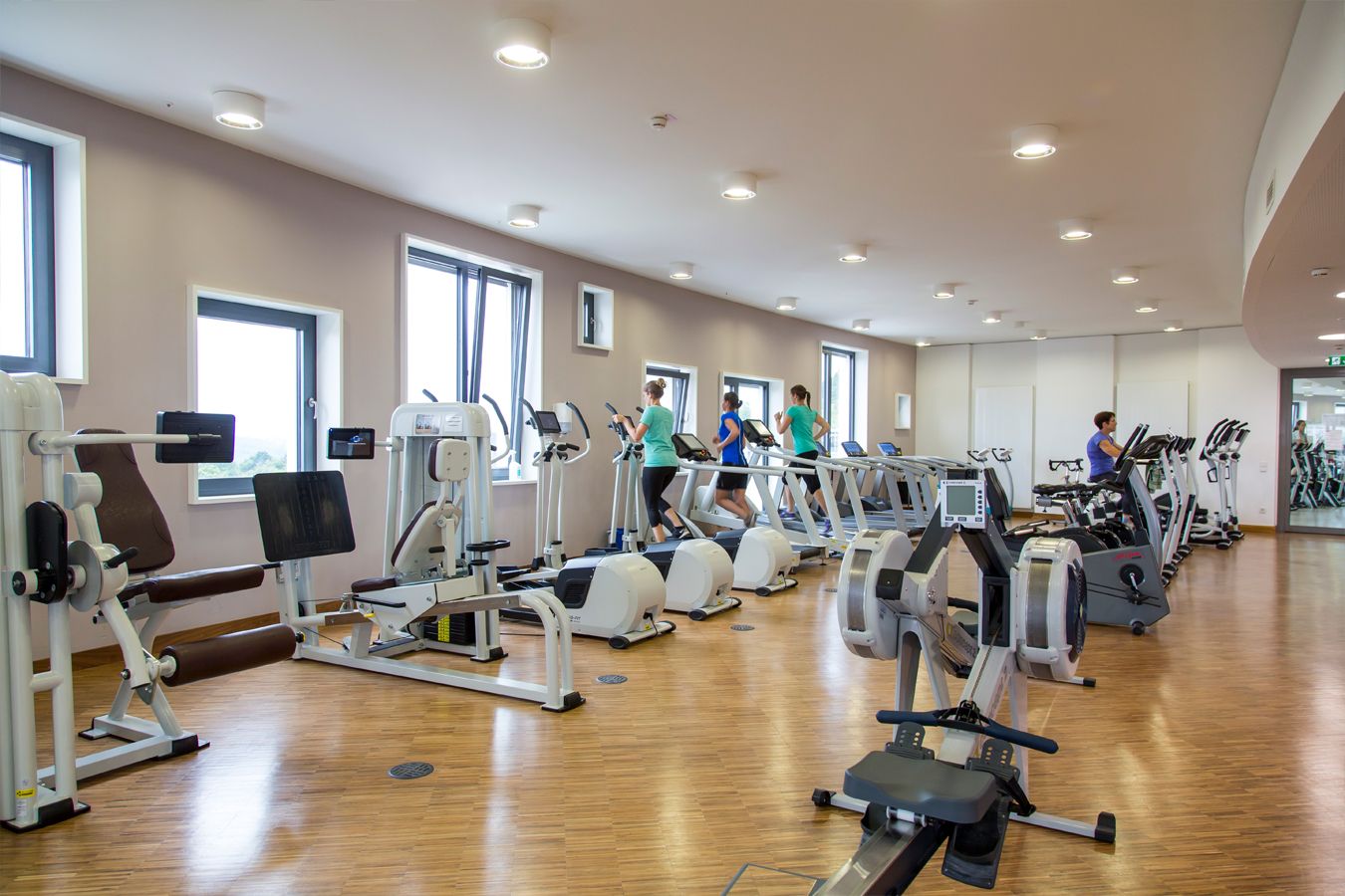 Trainsingsraum mit trainierenden Personen an Geräten