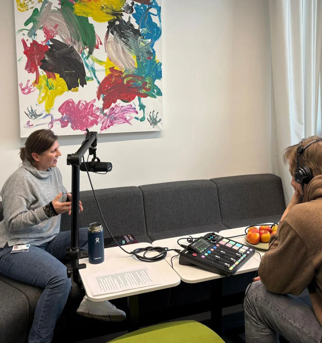 Standbild Podcast: Personen aus dem Interview sitzen an einem Tisch