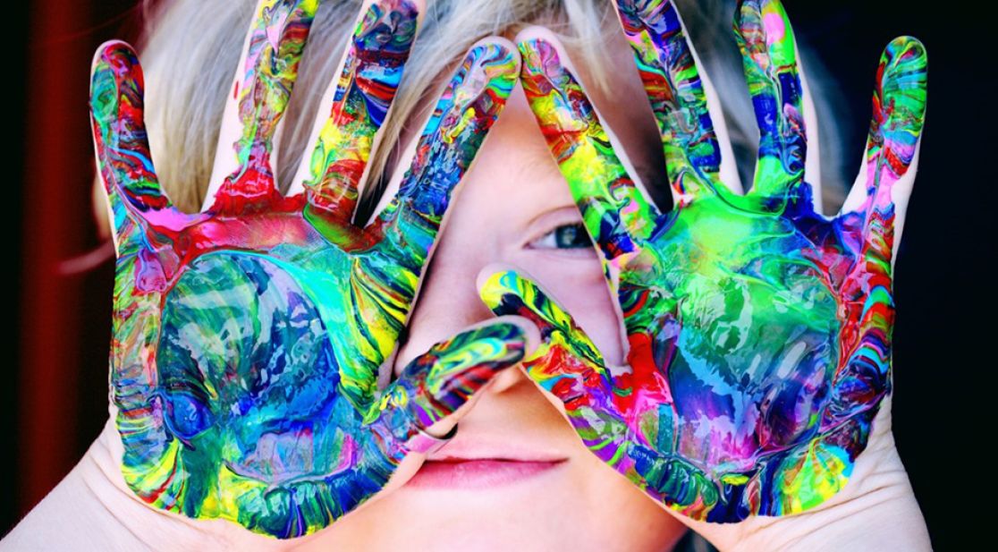 Kind zeigt bunt bemalte Hände