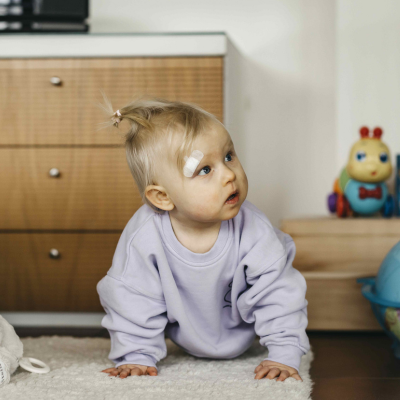 Die kleine Heidi in Krabbelposition seitlich hochblickend