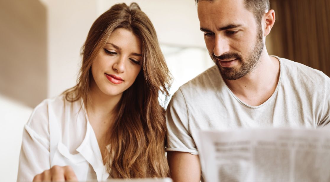 Decorative painting: young woman and young man sitting together at a table reading a journal