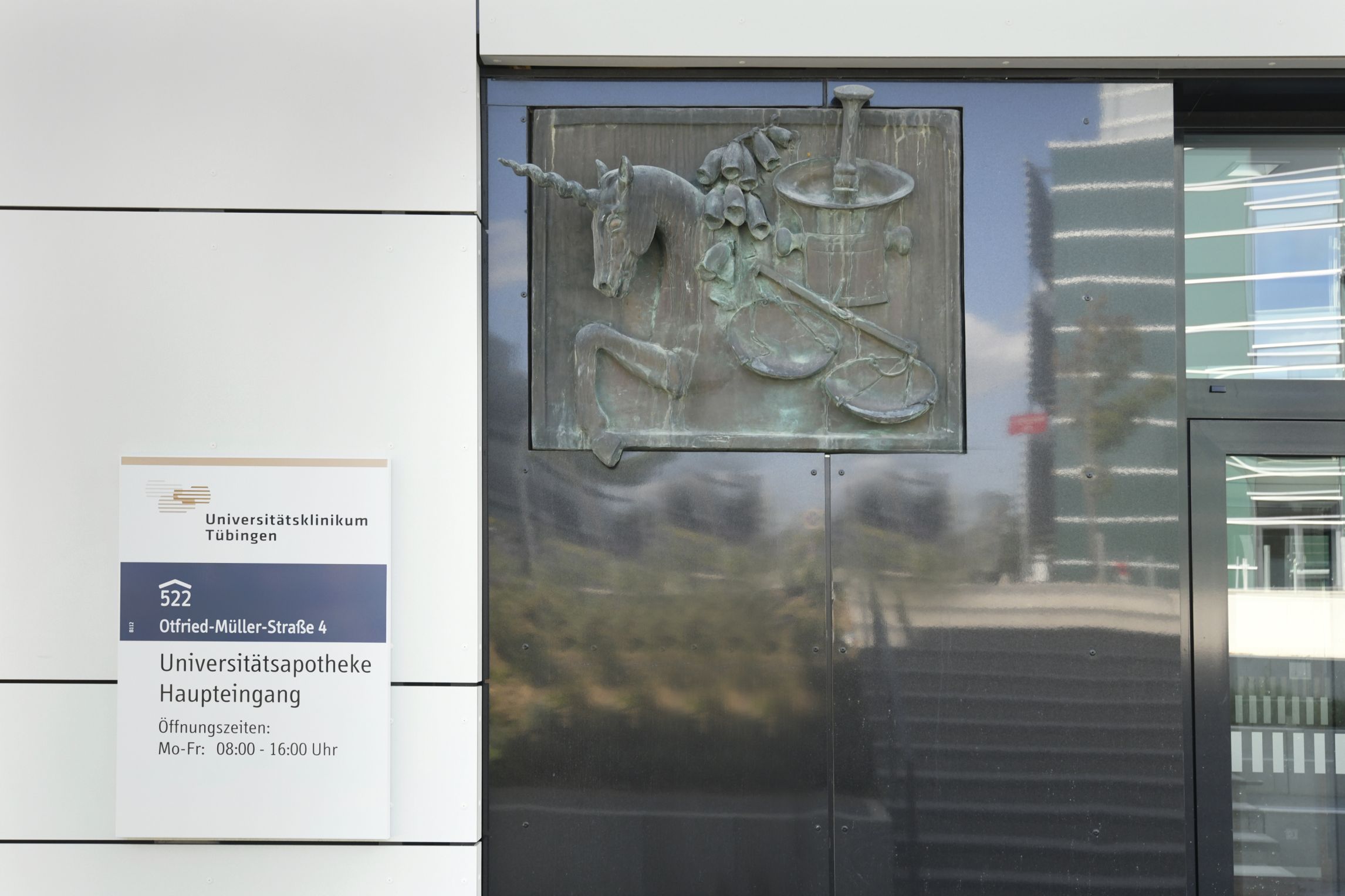 Außenansicht der Apotheke mit Gebäudeschild.