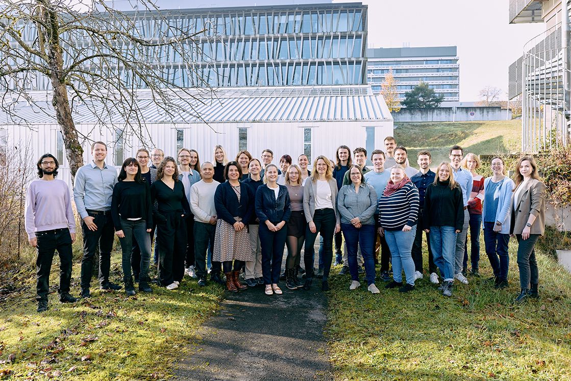 Gruppenfoto auf grüner Wiese vor einem Laborgebäude