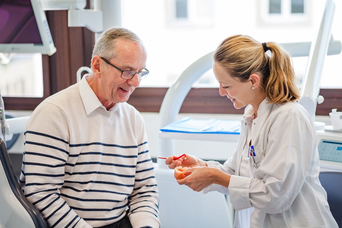 Mrs. Kramarczyck explains prophylaxis to Mr. Schiemann on the tooth model