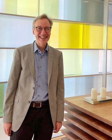 Thomas Dreher steht im Andachtsraum neben dem Altar