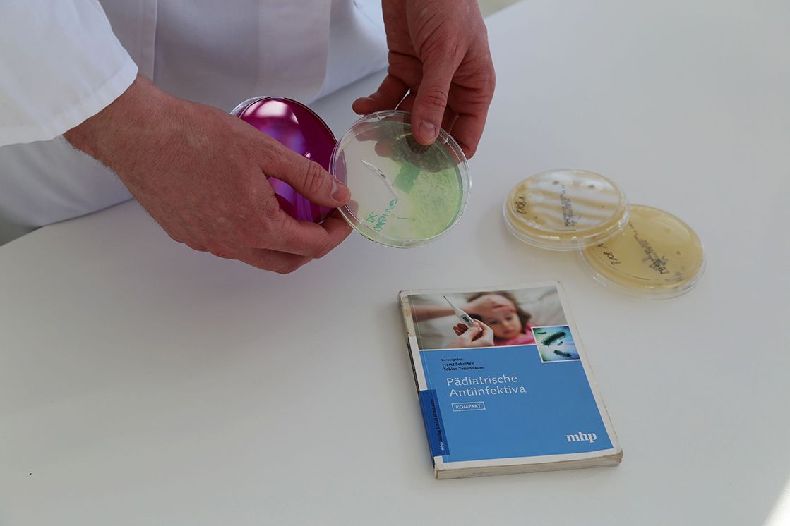 Petrischale und Fachbuch auf Tisch