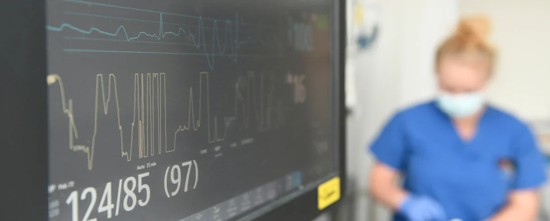 Überwachungsmonitor im Hintergrund Pflegerin