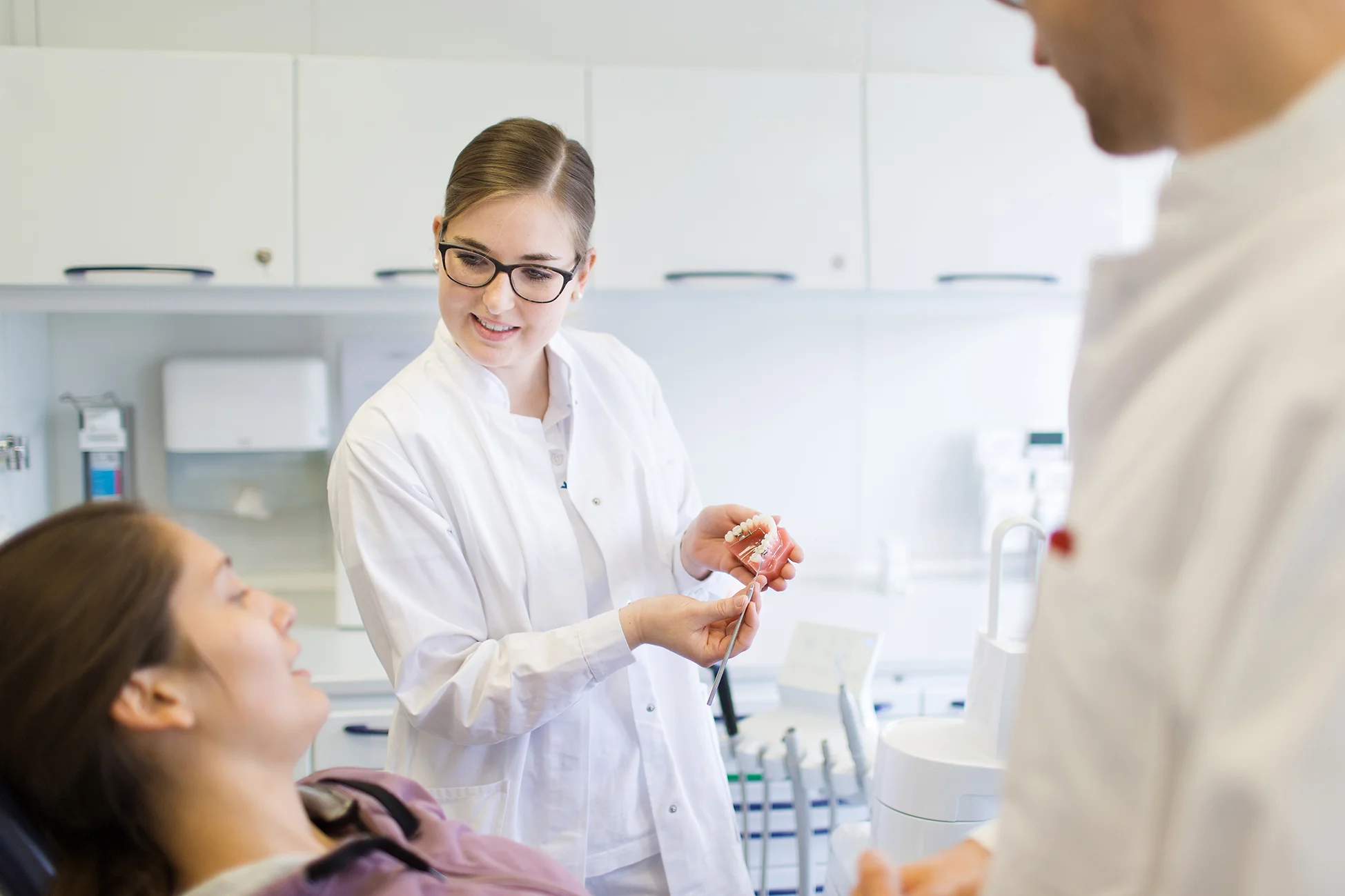 Prophylaxehelferin erjkärt am Zahnmodell die Entstehung von Zahnstein