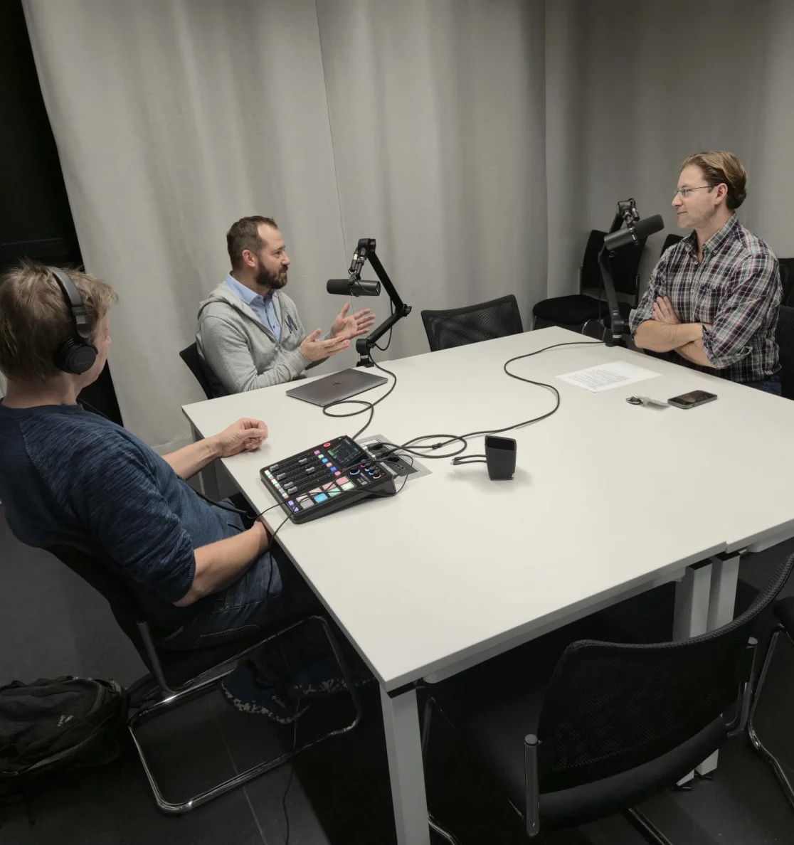 Standbild Podcast: Personen aus dem Interview sitzen an einem Tisch