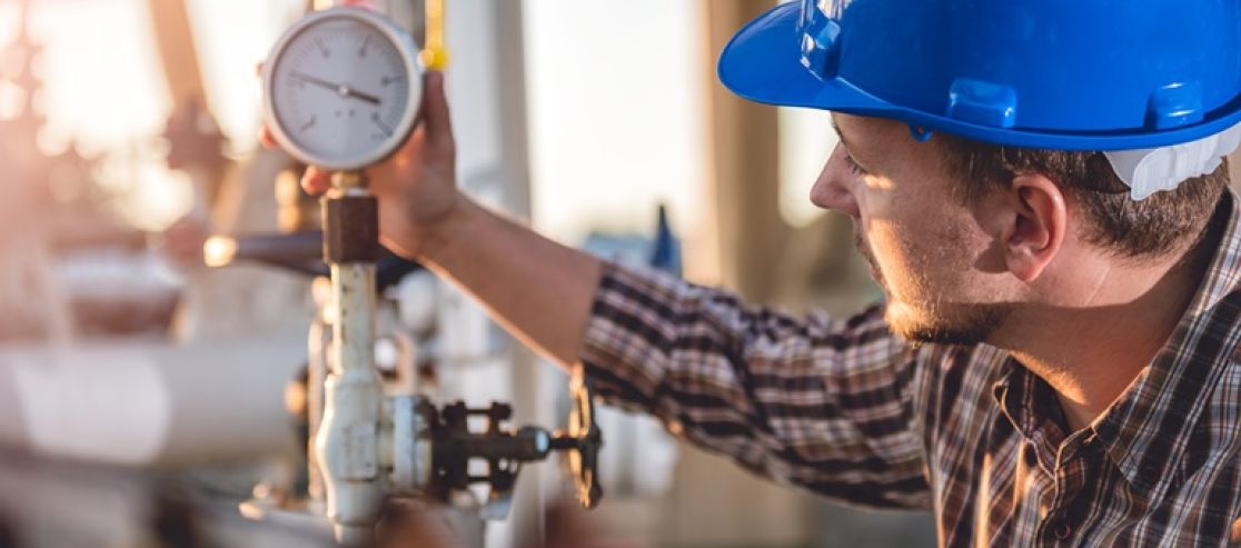 Mann mit Bauhelm und technische Anlage