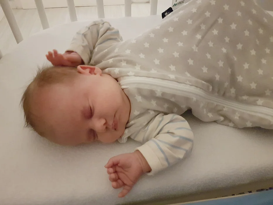 Schlafender Säugling im Kinderbett