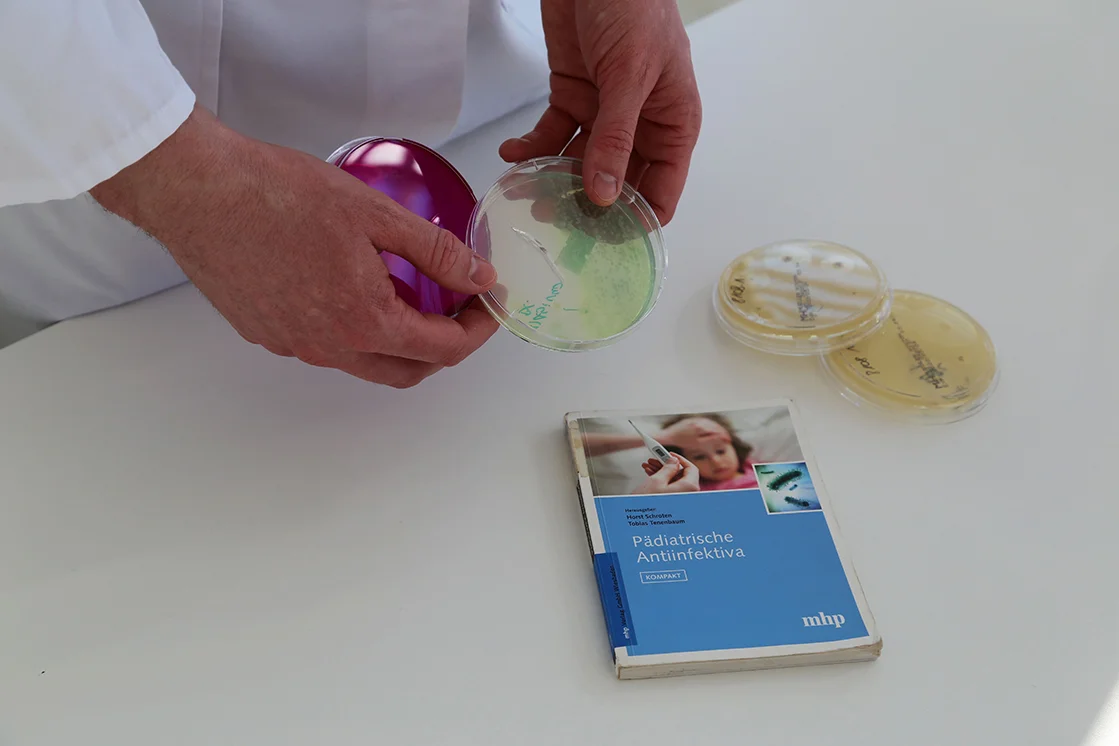 Petrischale und Fachbuch auf Tisch
