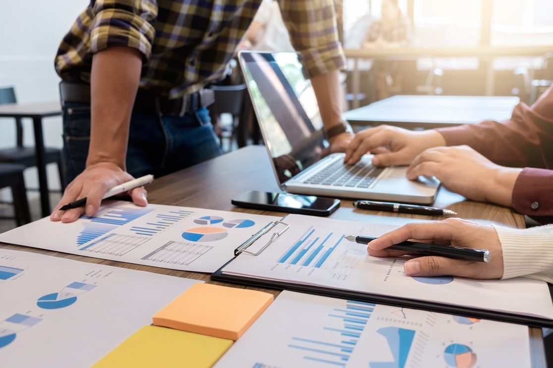 Diagramme auf Papier und ein Laptop