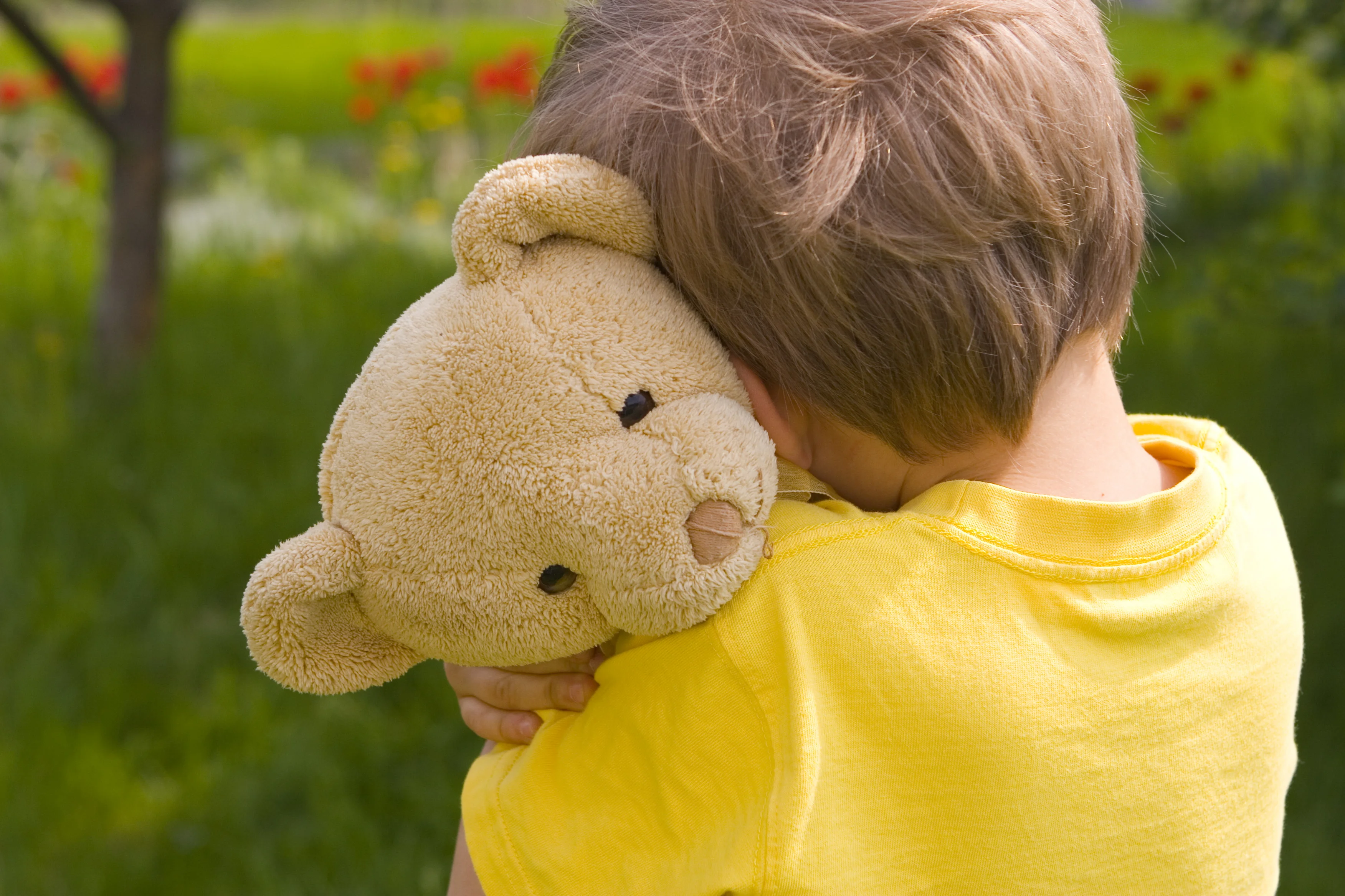 Kind mit Teddy im Arm