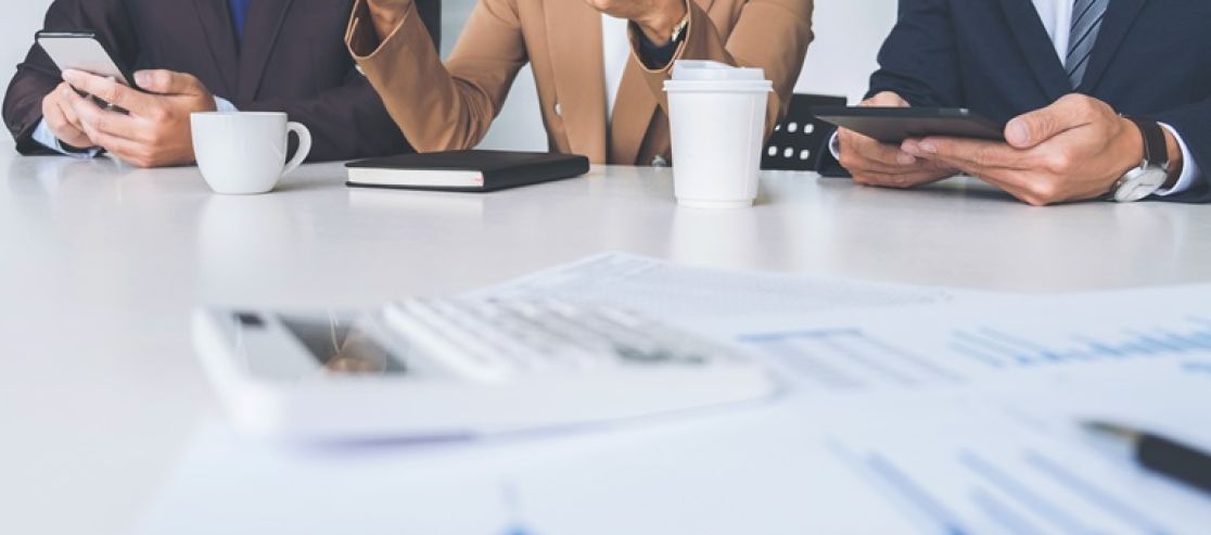 Drei Menschen an einem Besprechungstisch