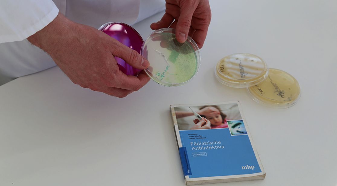 Schmuckbild Petrischale mit Fachbuch auf Tisch