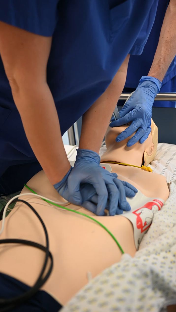 Videothumbnail: Reanimationspuppe wird mit Händen in blauen Handschuhen reanimiert