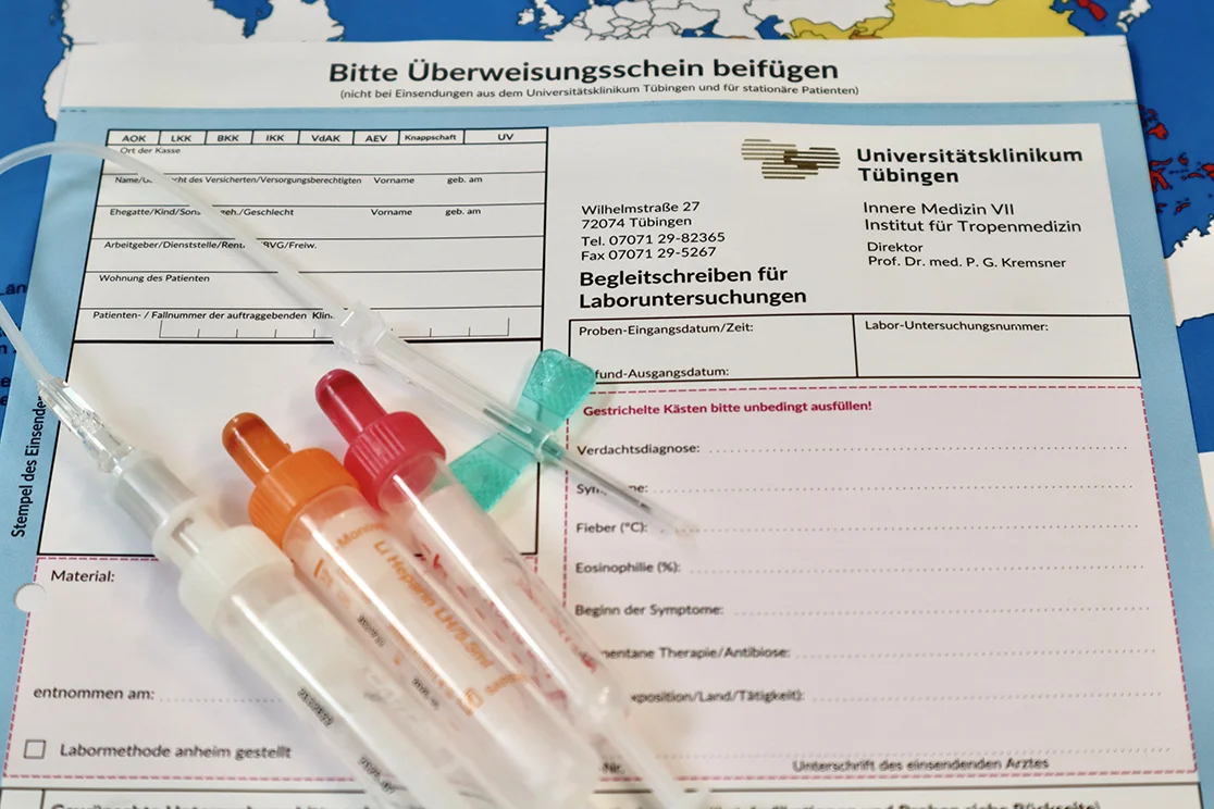 Impfseren und Kanülen vor Überweisungsschein