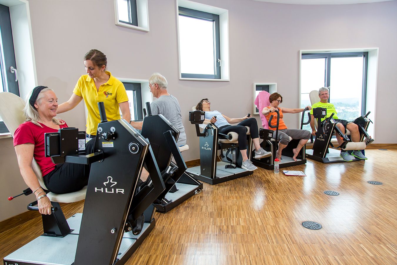 Personen trainieren mit Anleitung an Geräten