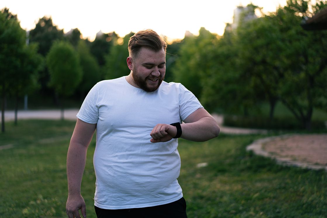 Mann beim Spaziergang schaut auf seine Smartwatch