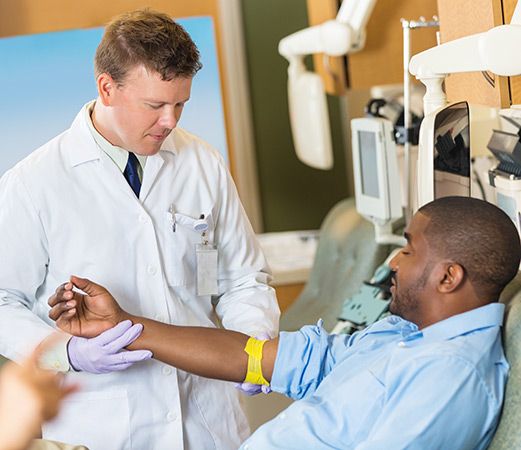 Arzt nimmt Patient Blut ab