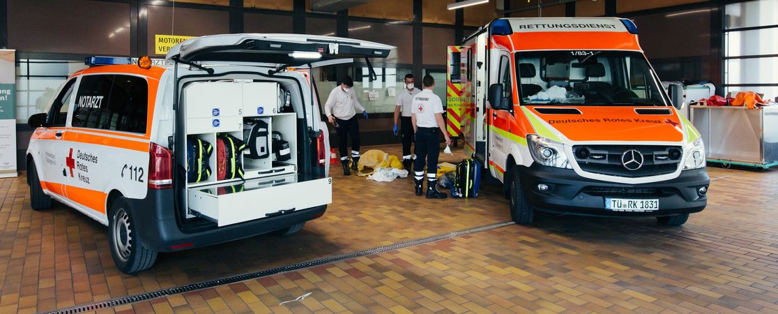 Notarztwagen mit Ausrüstung im Hintergrund Sanitäter