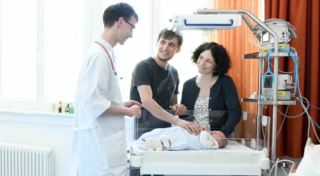 Familie mit Arzt und Neugeborenem in einem der Familienzimmer