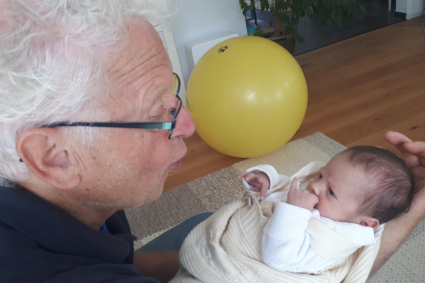 Großvater hält Enkelkind im Arm.