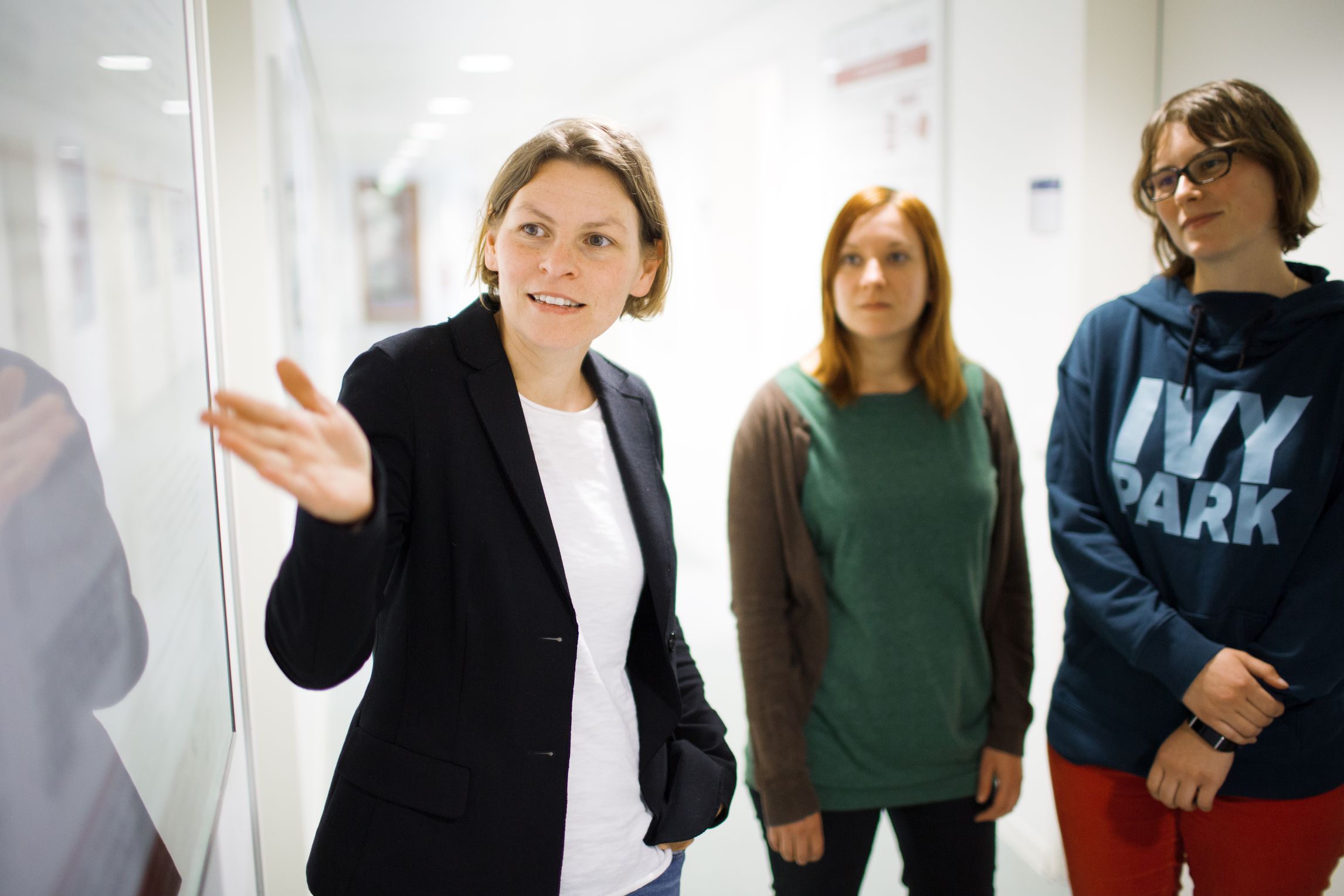 Frau erklärt einer kleinen Gruppe etwas