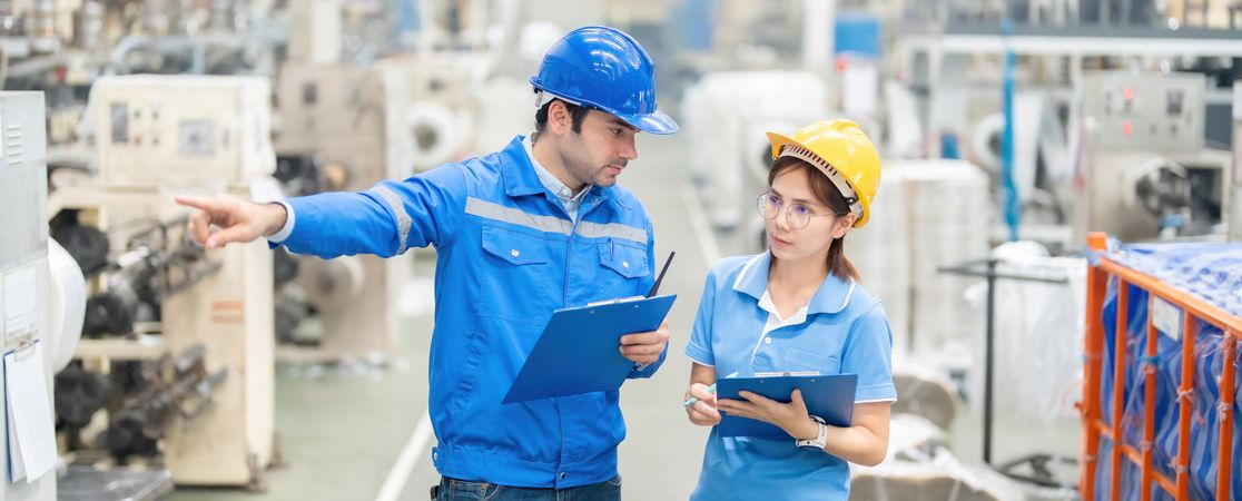 Zwei Personen mit Schutzausrtüstung bei einer Arbeitsplatzbegehung