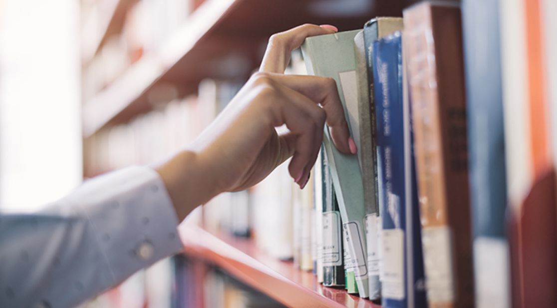 Hand greift nach Bücher