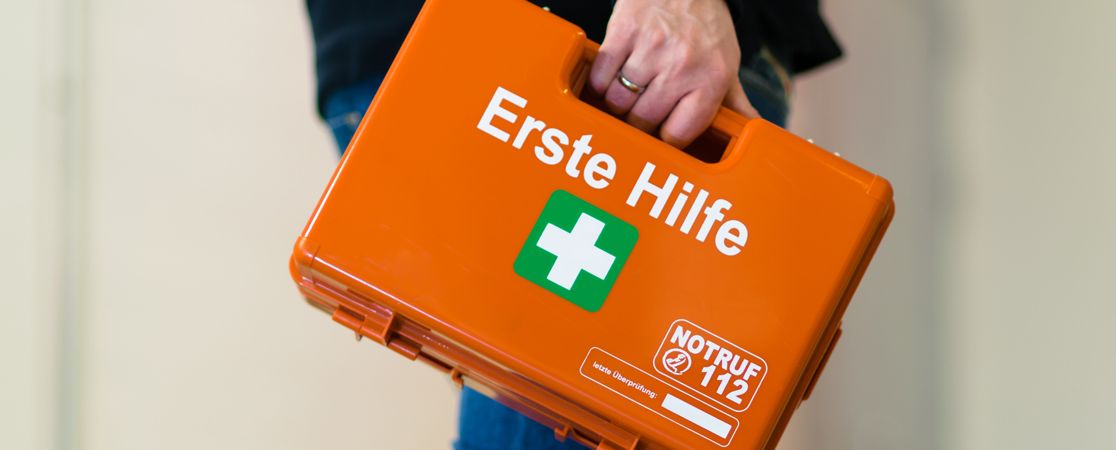 Hand träft einen Erste-Hilfe-Koffer