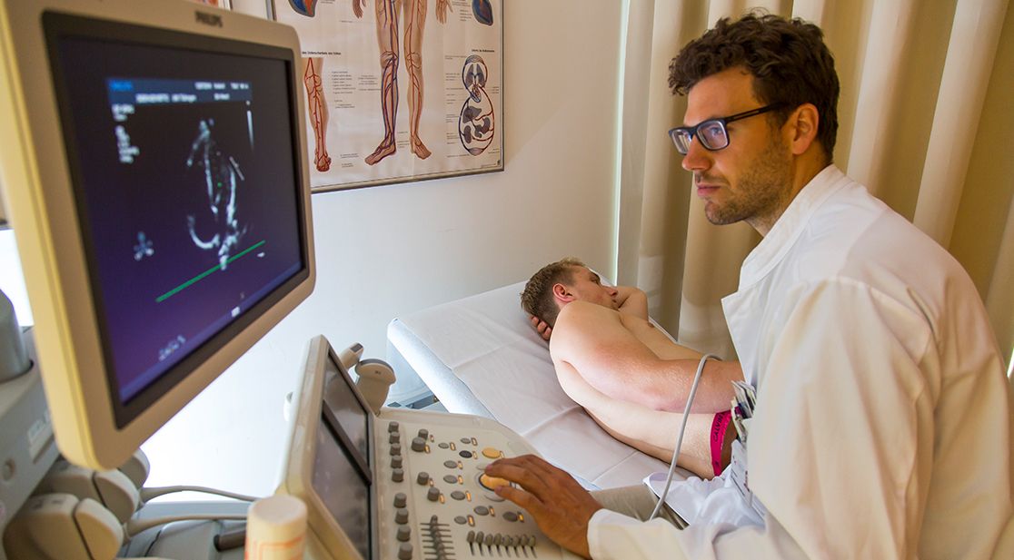 Schmuckbild: Arzt untersucht Patient auf Liege