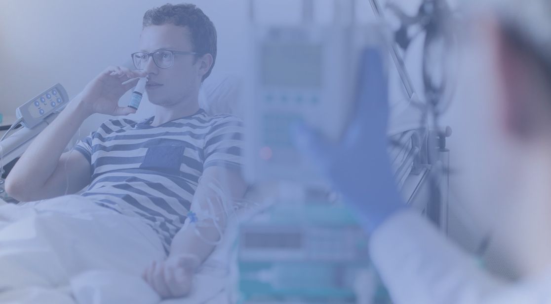 Mann liegt im Bett und benutzt ein Nasenspray