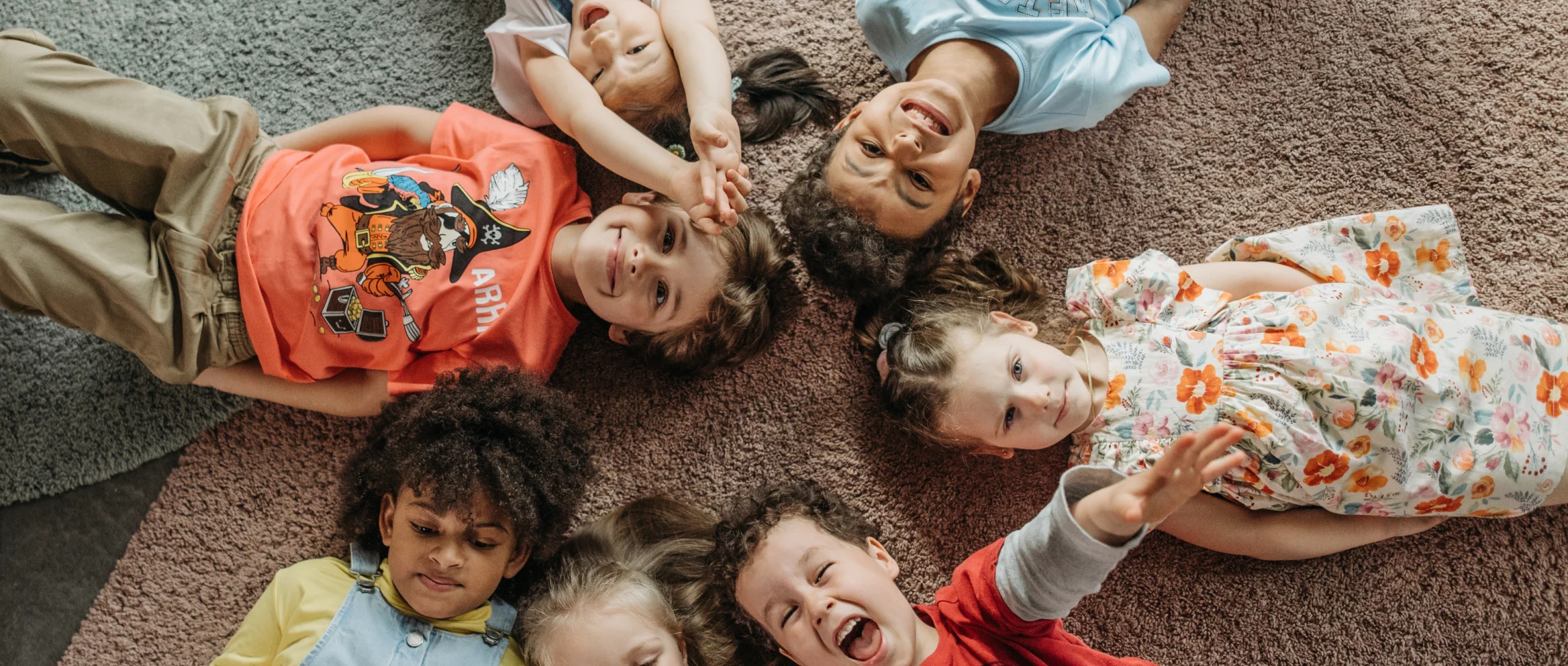 Kinder liegen auf dem Rücken und lachen