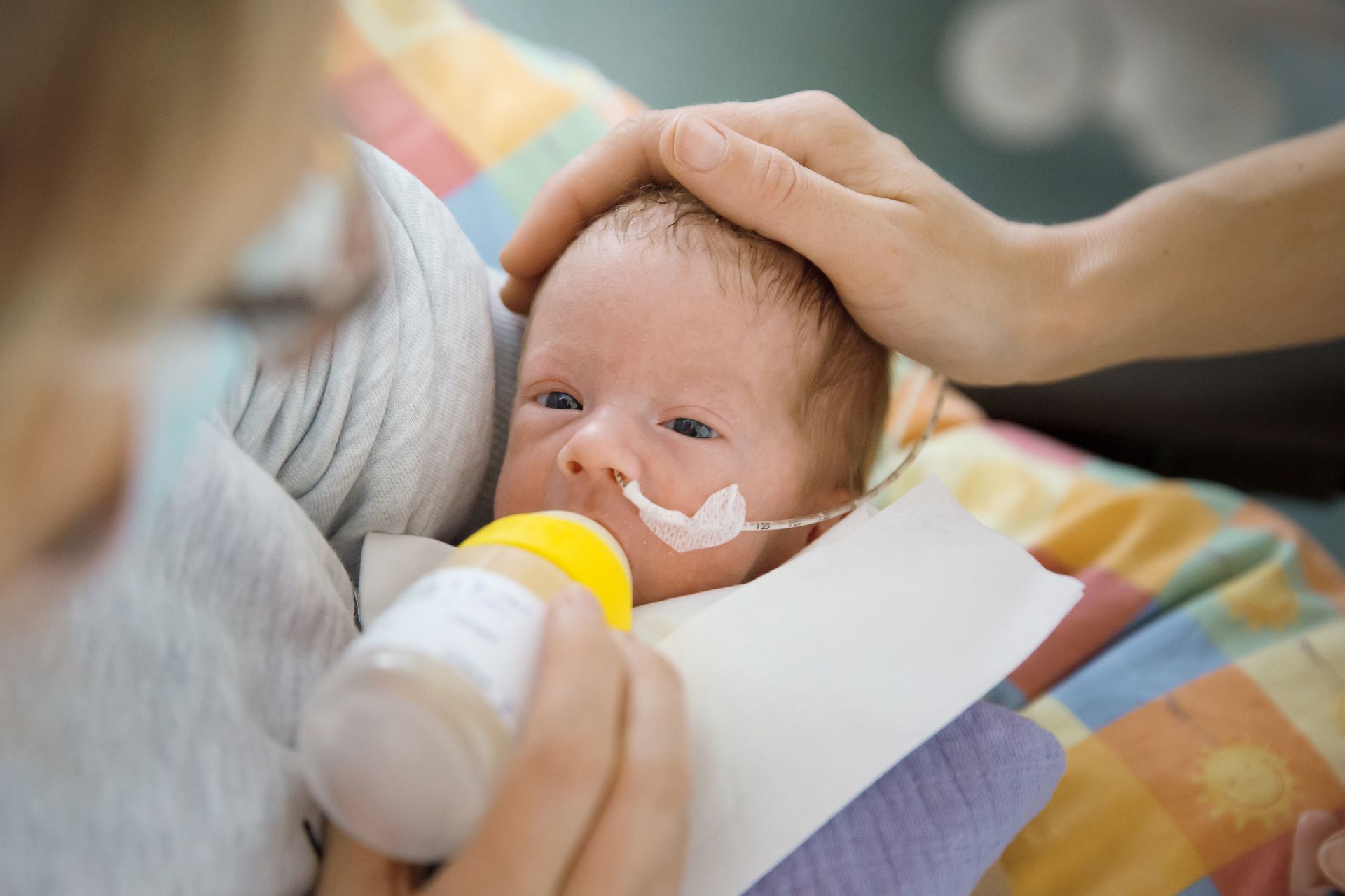 Frühgeborenes erhält eine Milchflasche
