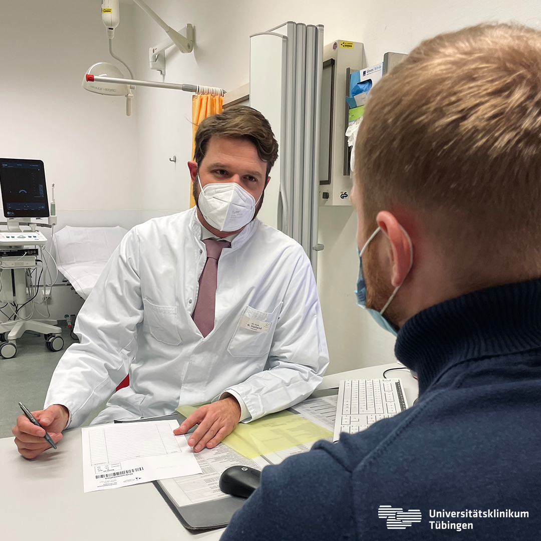 Dr. Niklas Harland spricht mit einem Patienten.