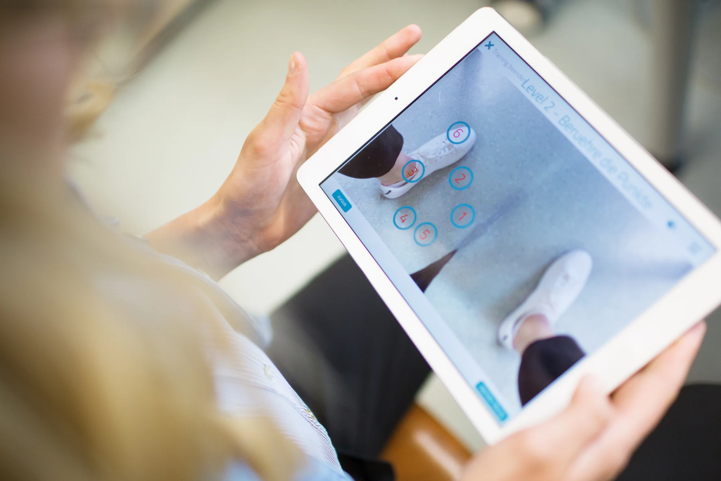 Person hält ein Tablet, auf dem eine spezifische Anwendung geöffnet ist