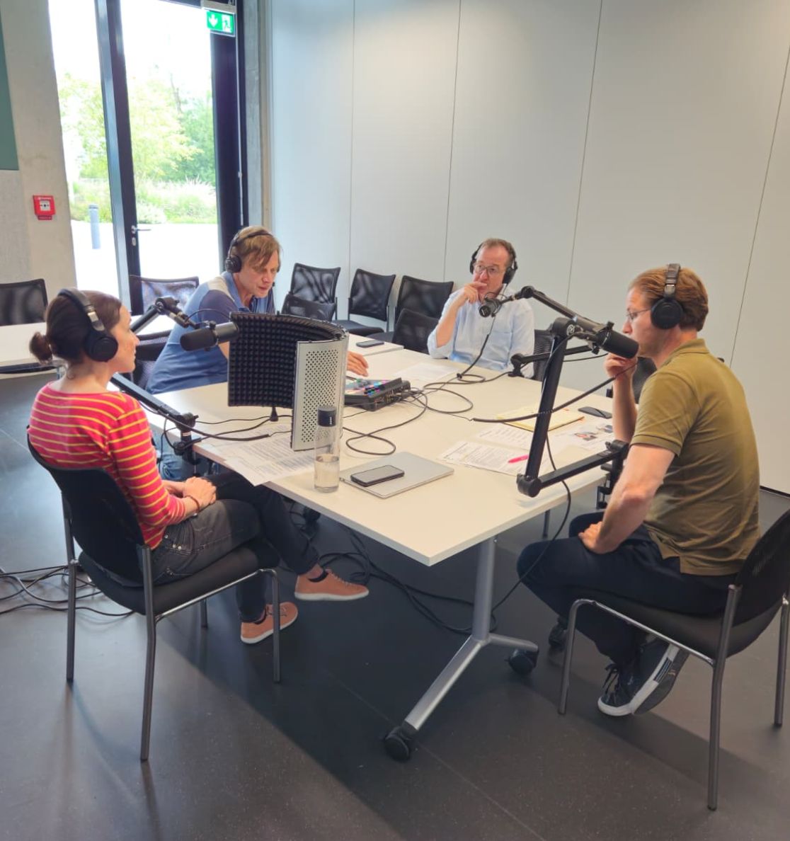 Standbild Podcast: Personen aus dem Interview sitzen an einem Tisch