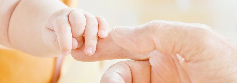 Erwachsenenhand greift Kinderhand