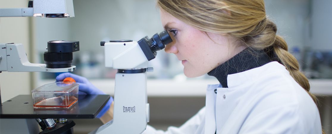 Junge Forscherin am Mikroskop