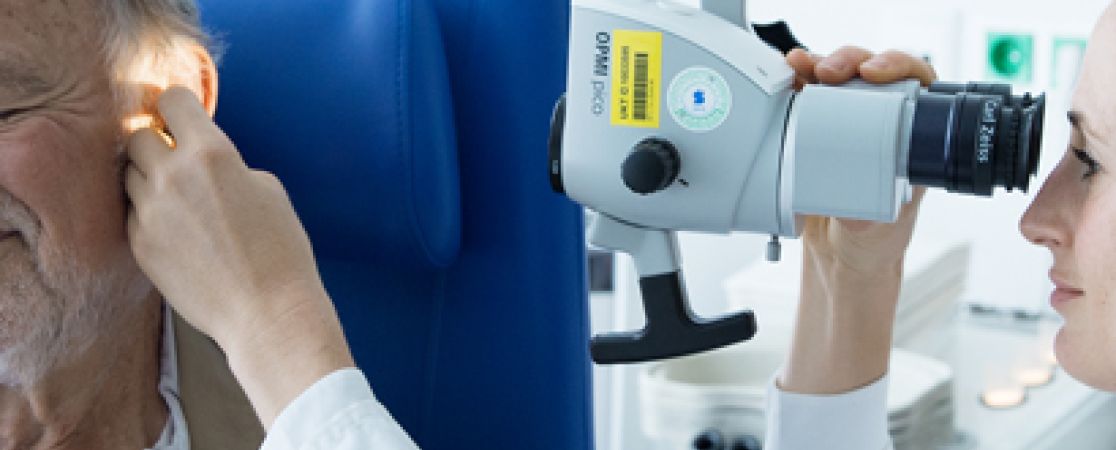 Ärztin untesucht Ohr eines Patienten