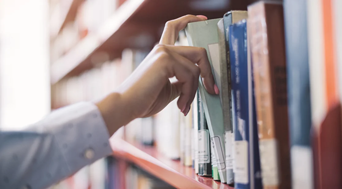 Hand greift nach Bücher