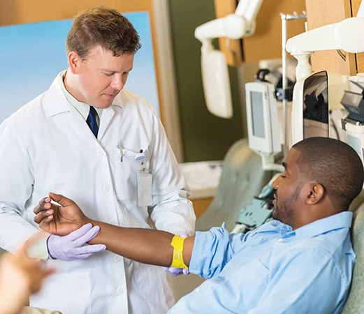 Arzt nimmt Patient Blut ab