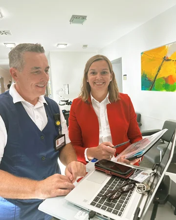 Carmen Renz im roten Jacket mit einem Kollegen am Schreibtisch