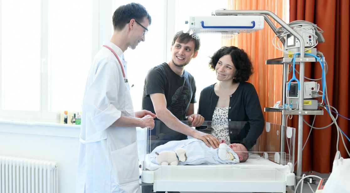 Familie mit Arzt und Neugeborenem in einem der Familienzimmer
